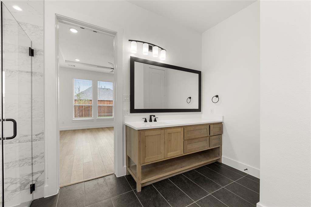 981 Georgetown Place Prosper, TX 75078 - Photo 18 of 30 a bathroom with a sink a mirror and shower