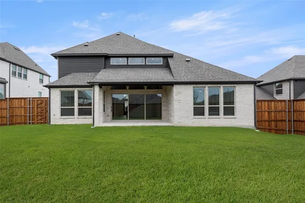 a view of a house with a big yard and large trees