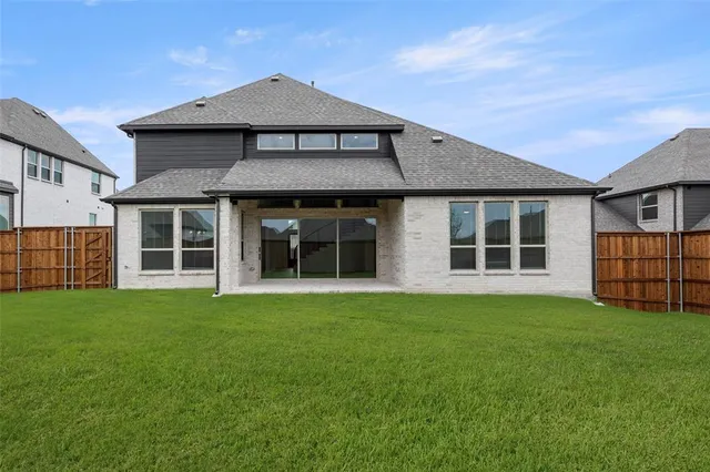 a view of a house with a big yard and large trees