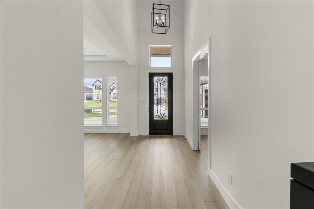 981 Georgetown Place Prosper, TX 75078 - Photo 3 of 30 an empty room with wooden floor and a window