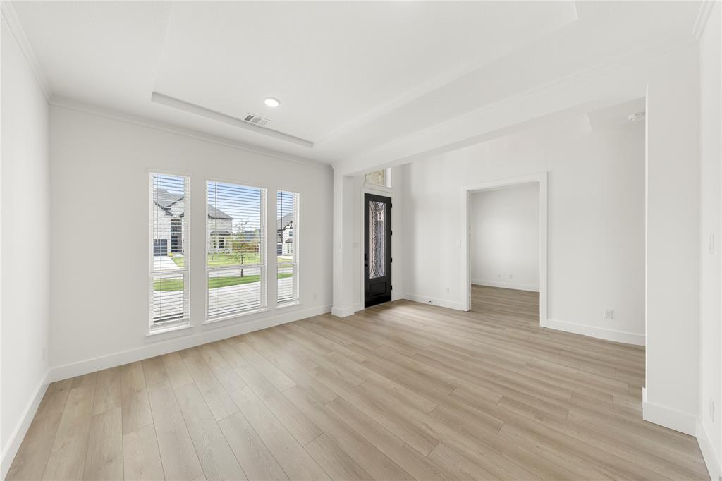 981 Georgetown Place Prosper, TX 75078 - Photo 5 of 30 a view of an empty room with wooden floor and a window