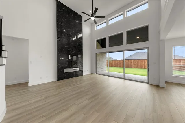 a view of an empty room with window and wooden floor