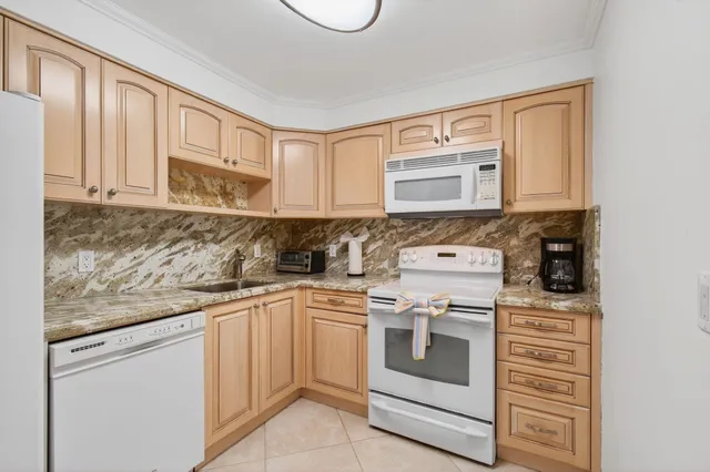 a kitchen with stainless steel appliances granite countertop a refrigerator and a stove