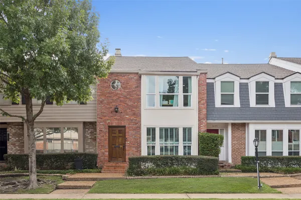 front view of a brick house with a yard