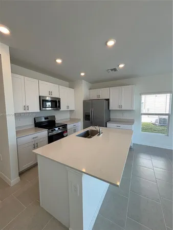 a kitchen with stainless steel appliances a refrigerator sink stove microwave and cabinets