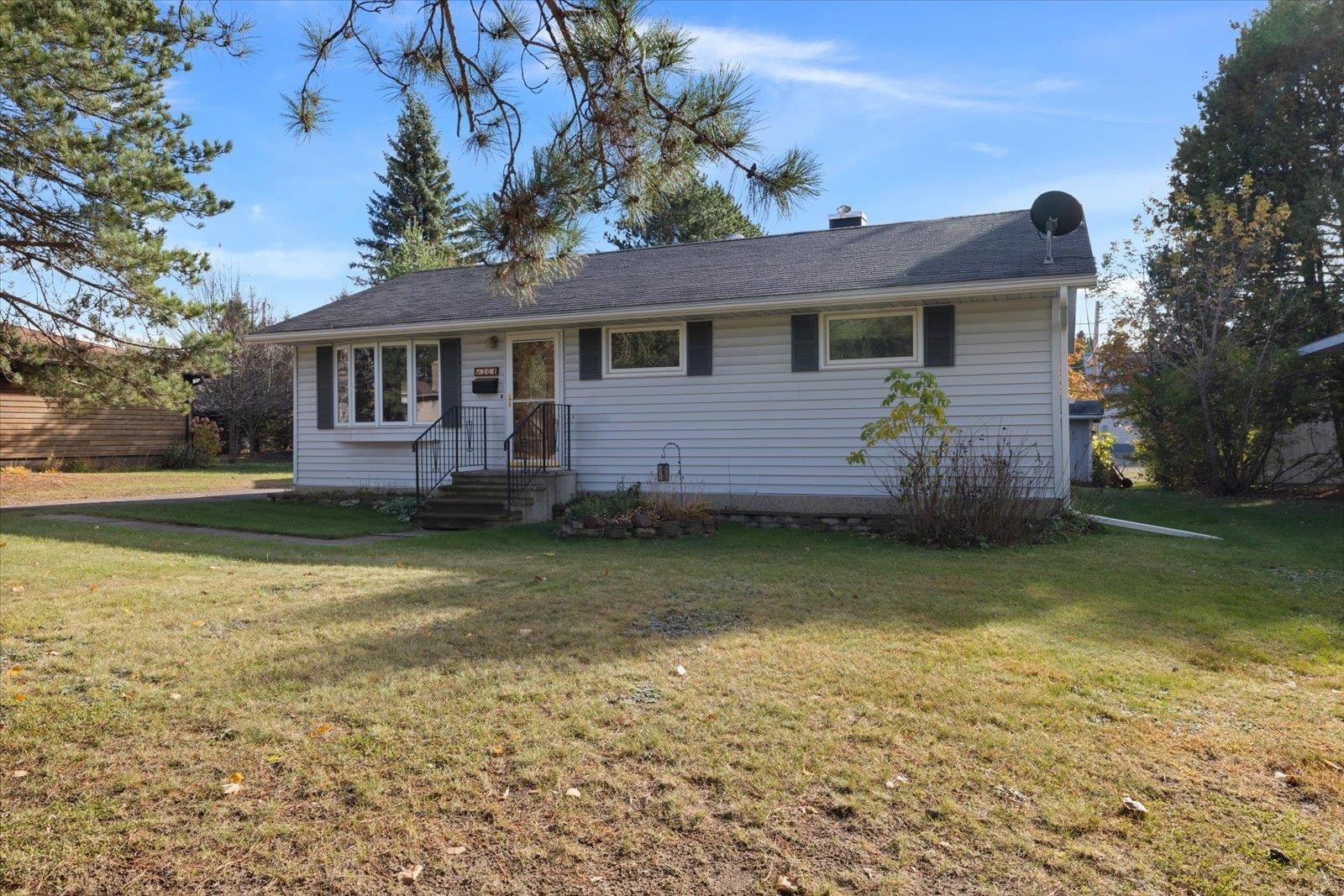 Ranch-style house with a front yard and a chimney