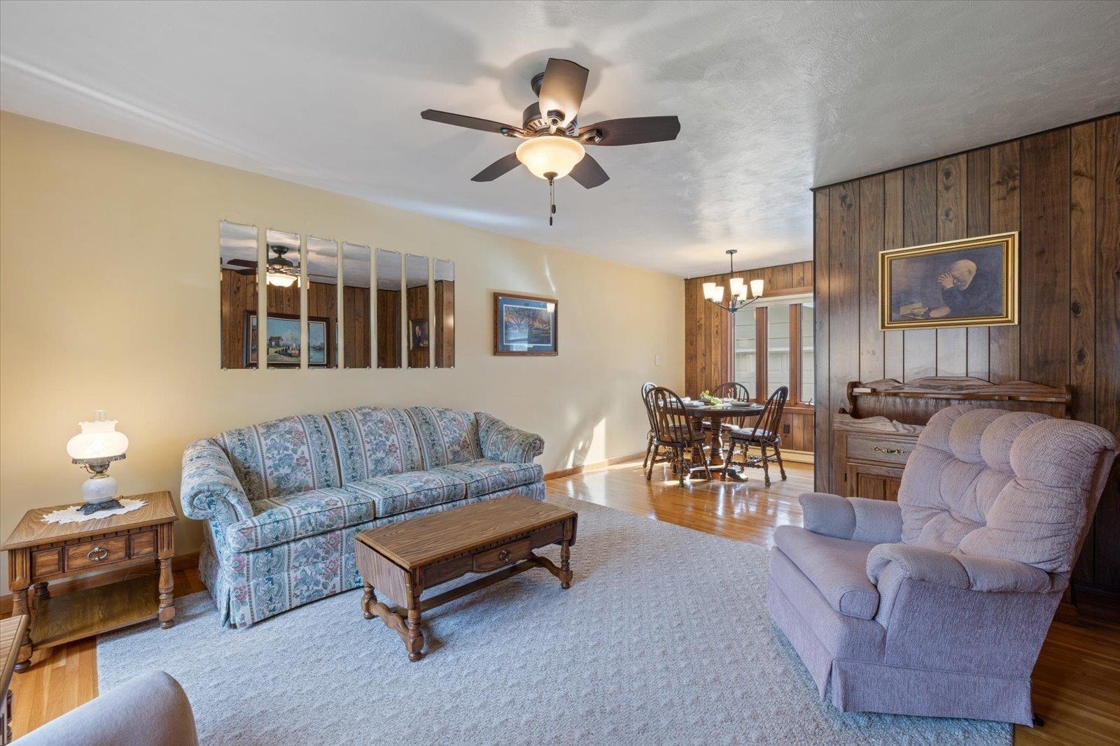 36 East Beacon Hill Road Ely, MN 55731 - Photo 9 of 30 Living room with wood finished floors, wooden walls, a chandelier, and ceiling fan