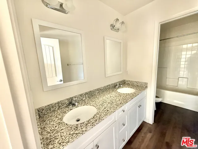 a bathroom with a granite countertop sink and a bathtub
