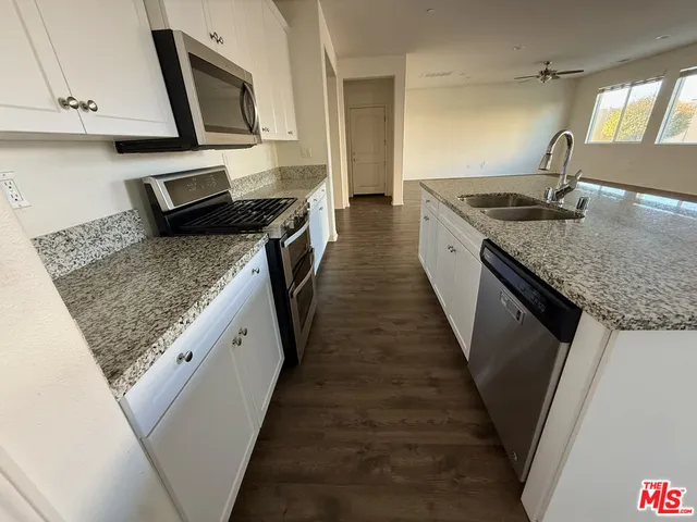 a kitchen with sink stove and cabinets