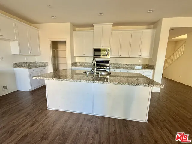 a view of kitchen with wooden floor and electronic appliances