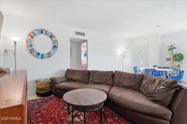 a living room with furniture a rug and a wall painting