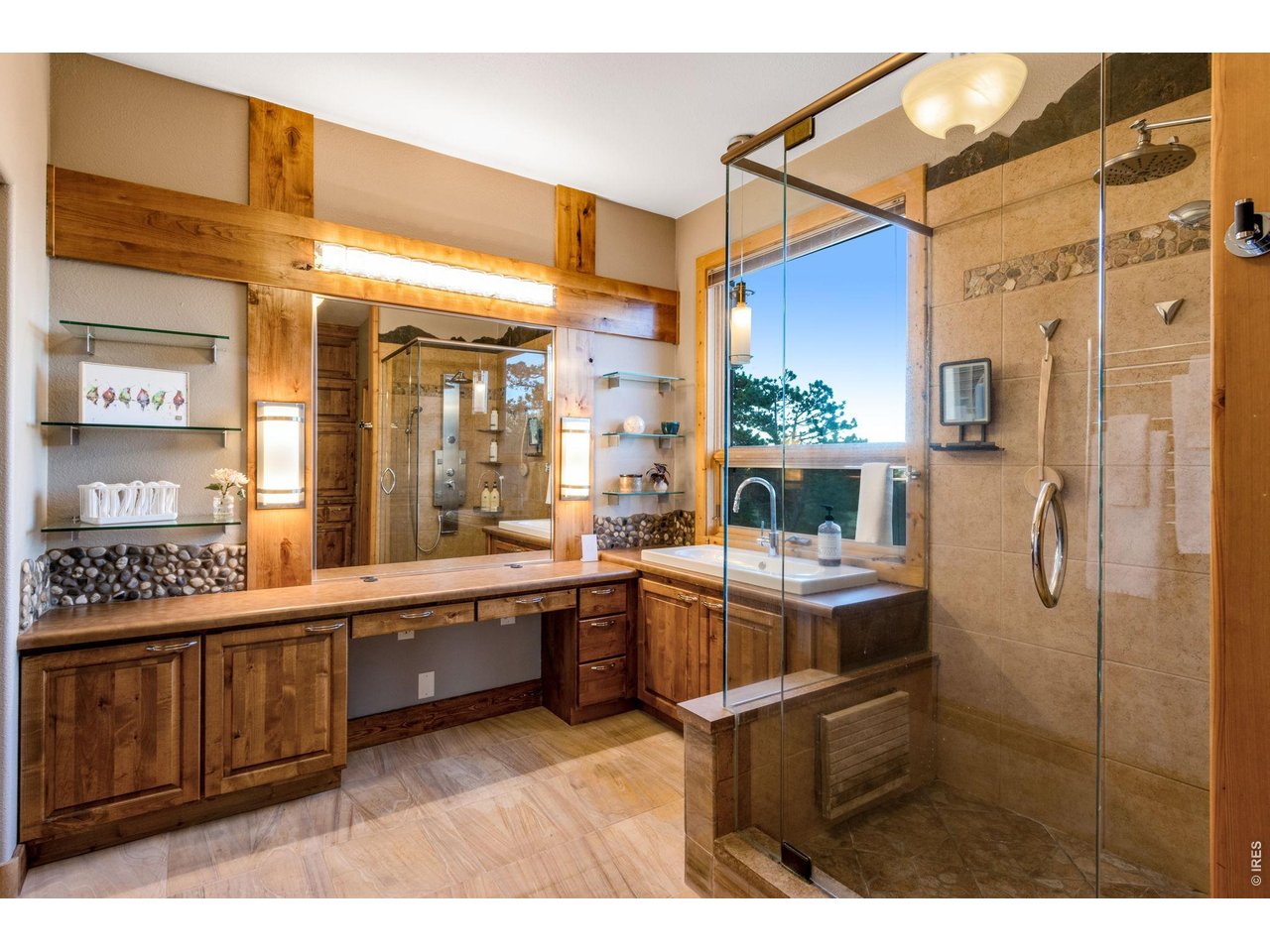 5433 North Rim Road Livermore, CO 80536 - Photo 28 of 50 walk-in closet, luxury private bath featuring built-in cabinetry, sandstone tile flooring with radiant in-floor heat, heated towel rack, shower with overhead + 6 body jets and a wand, 2 lifted vanities, door to throne, glass shelving