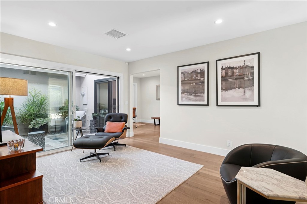 3 Rue Cannes Newport Beach, CA 92660 - Photo 6 of 46 Sunlit living space featuring expansive glass doors that frame garden views and enhance the home’s indoor-outdoor flow.