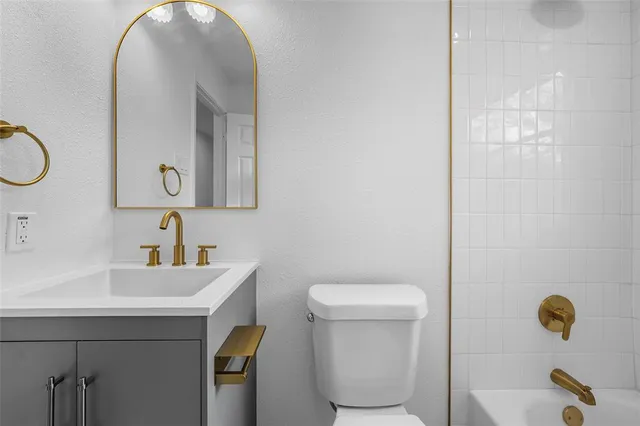 a bathroom with a sink a toilet and mirror