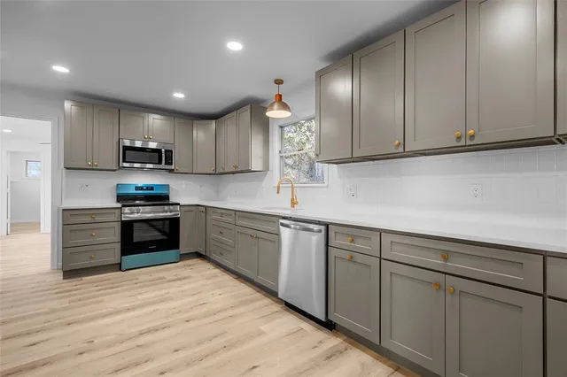 a kitchen with granite countertop wooden cabinets and stainless steel appliances