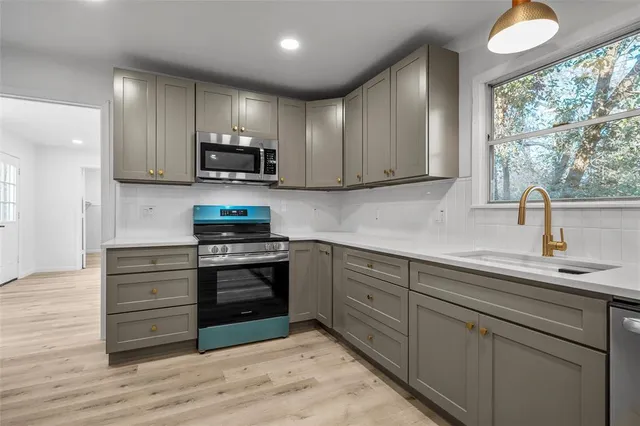 a kitchen with stainless steel appliances granite countertop a sink a stove and a refrigerator