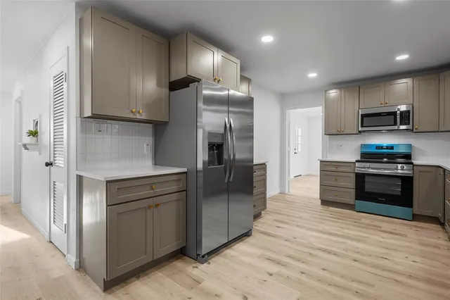a kitchen with stainless steel appliances kitchen island granite countertop a refrigerator and a stove