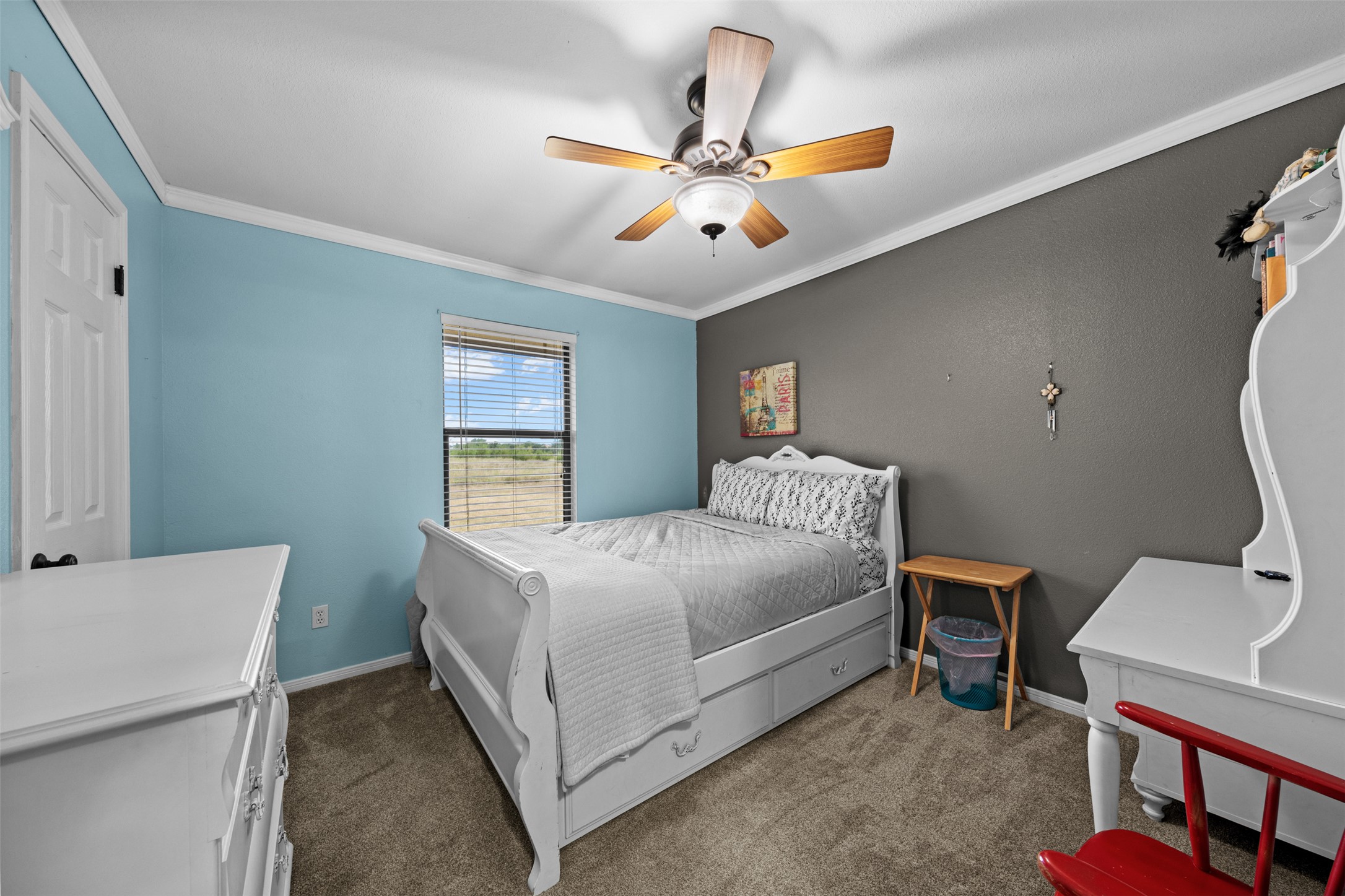 1512 Panther Loop Pflugerville, TX 78660 - Photo 9 of 40 A comfortable bedroom with a window offering scenic outdoor views and a ceiling fan for climate control.