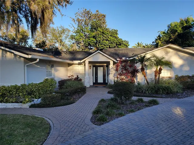 a front view of a house with a yard and potted plants