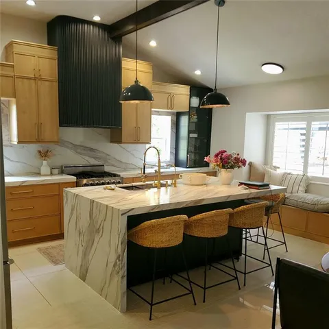a kitchen with a sink and chairs