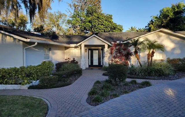 a front view of a house with a yard and potted plants