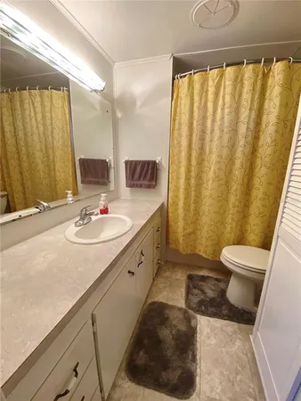 a bathroom with a sink a toilet and mirror