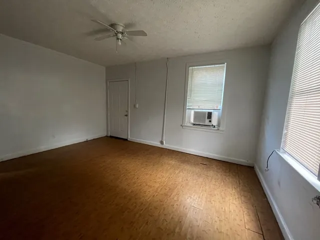 an empty room with a window and wooden floor