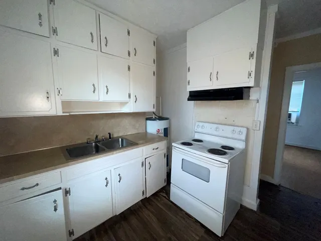a kitchen with white cabinets and white appliances