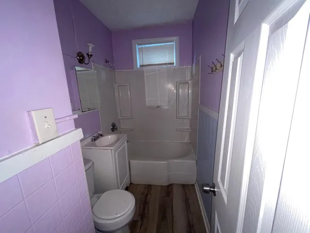 a white toilet sitting next to a bath tub
