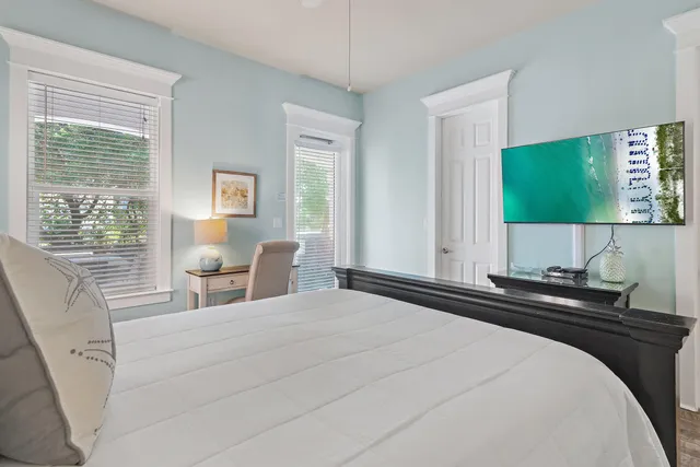 a bedroom with a bed and a flat tv screen on dresser