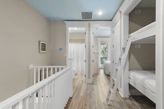 a view of a hallway with a white walls and wooden floor