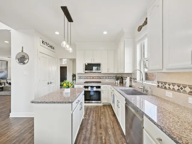 a kitchen with granite countertop cabinets a dining table and chairs