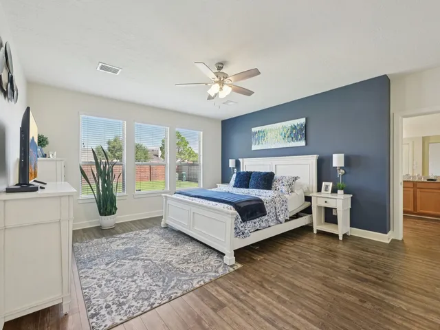 a dining room with wooden floor a chandelier a wooden table and chairs