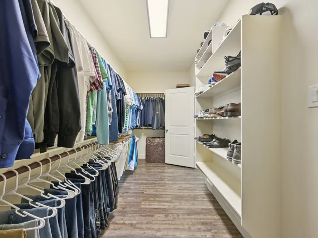 a spacious bathroom with a granite countertop double vanity sink a mirror and a bathtub