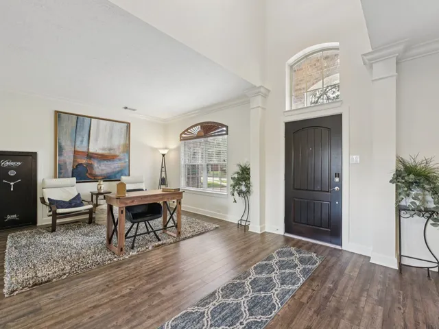a living room with furniture and a wooden floor