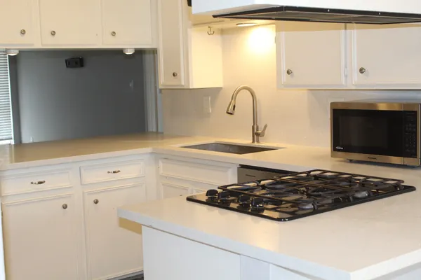 a white stove top oven sitting inside of a kitchen