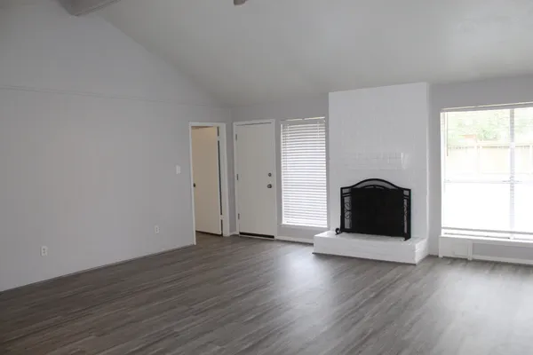 an empty room with wooden floor and fireplace