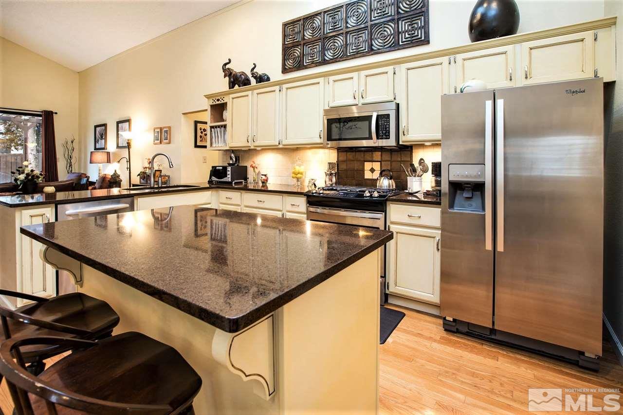 145 Riverhaven Place Reno, NV 89519 - Photo 8 of 23 a kitchen with stainless steel appliances granite countertop a sink a stove and a refrigerator