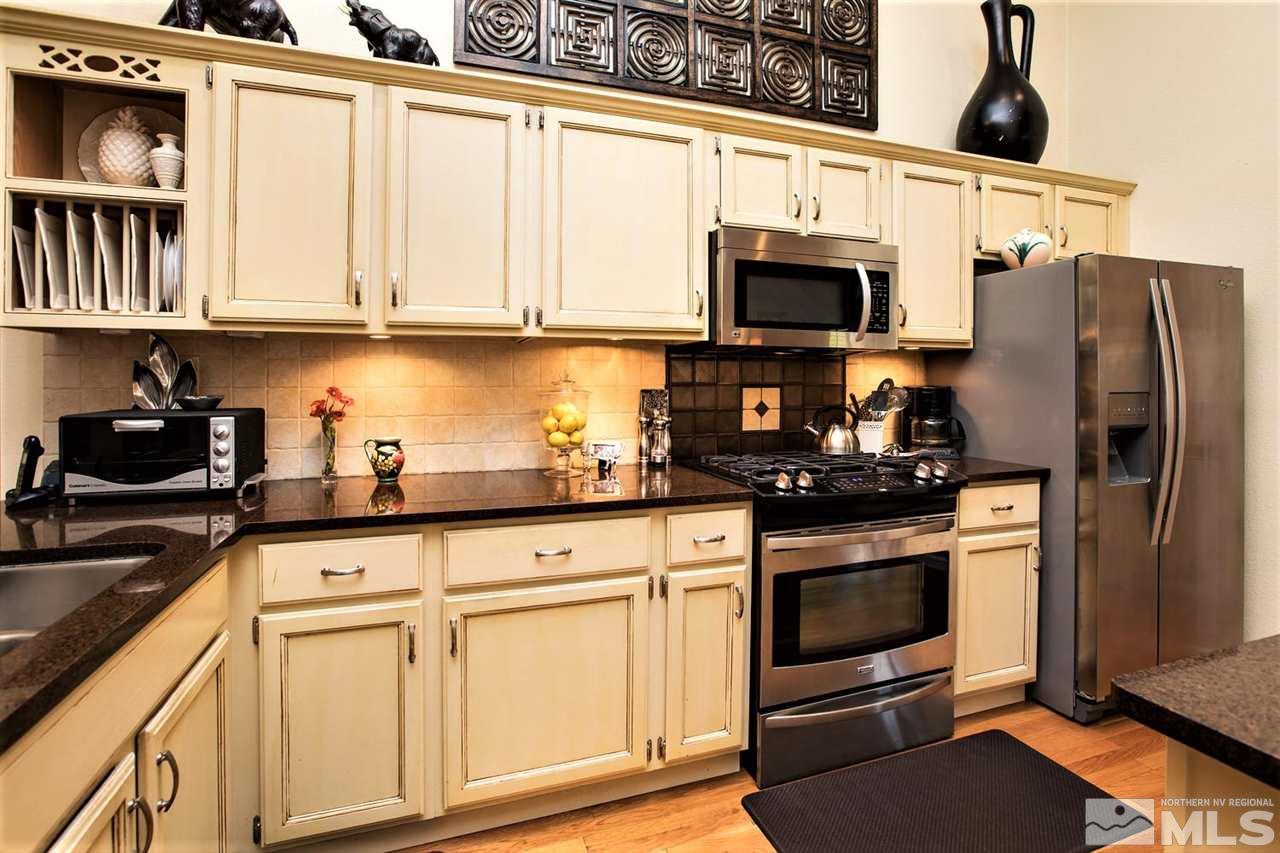 145 Riverhaven Place Reno, NV 89519 - Photo 9 of 23 a kitchen with stainless steel appliances granite countertop a refrigerator stove and sink