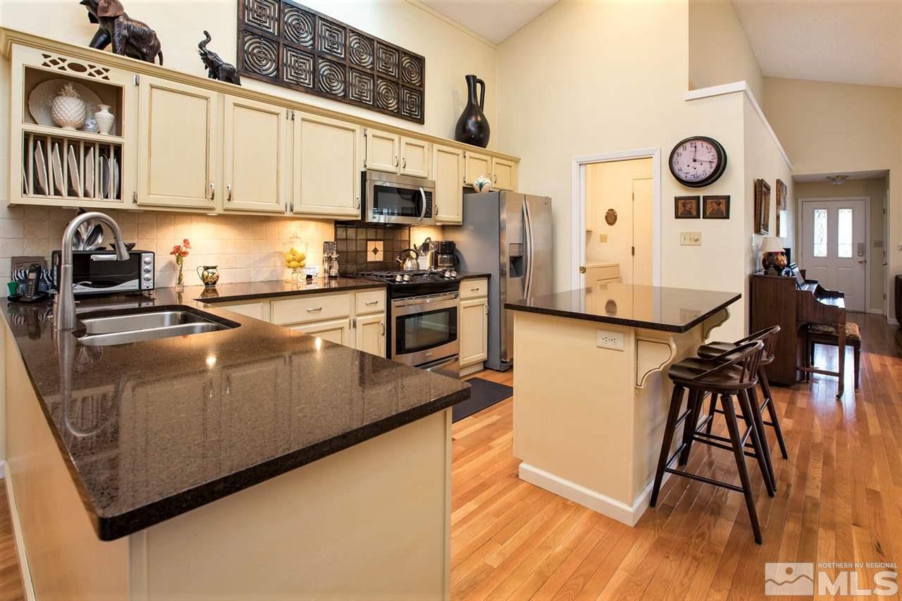 145 Riverhaven Place Reno, NV 89519 - Photo 10 of 23 a kitchen with stainless steel appliances granite countertop a stove a sink a refrigerator and white cabinets