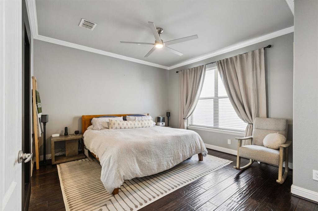 722 East 1st Street Fort Worth, TX 76102 - Photo 13 of 25 Sizable primary bedroom featuring gorgeous hardwood flooring and crown molding.
