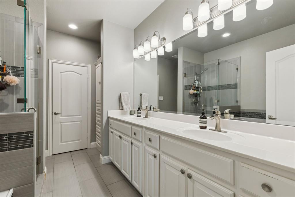 722 East 1st Street Fort Worth, TX 76102 - Photo 16 of 25 Large en suite primary bathroom feauturing dual sinks and lots of cabinetry for storage. The walk-in closet has been transformed with a new organization system.