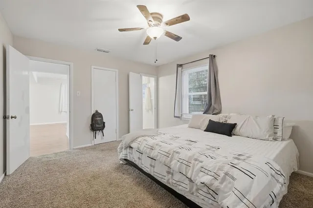 a bedroom with a large bed and a chandelier