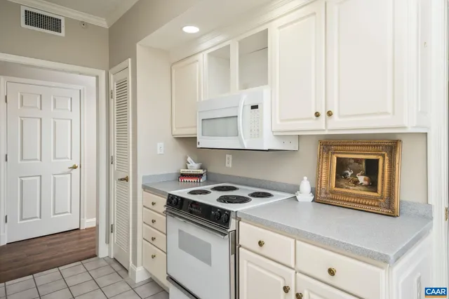 a kitchen with granite countertop white cabinets and black appliances