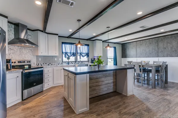 a kitchen with granite countertop a stove and a wooden floors