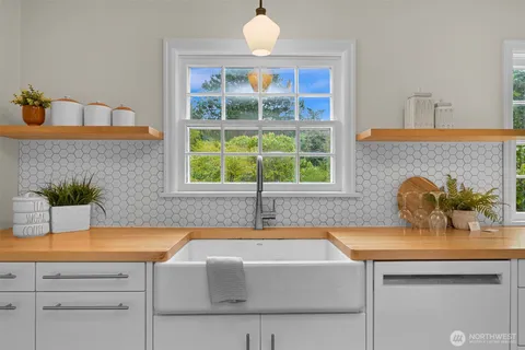 a bathroom with a tub a sink and a window