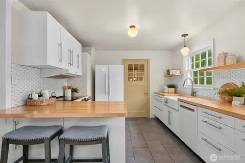 a kitchen with white cabinets and sink
