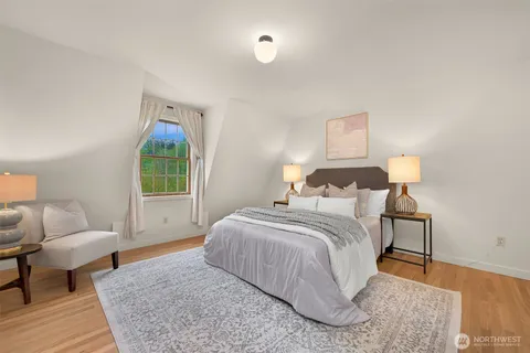 a spacious bedroom with a bed a couch and a window