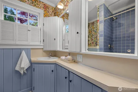 a bathroom with a granite countertop sink and a window
