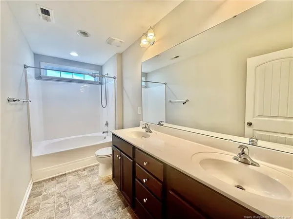 a bathroom with a sink double vanity granite tub shower and a mirror